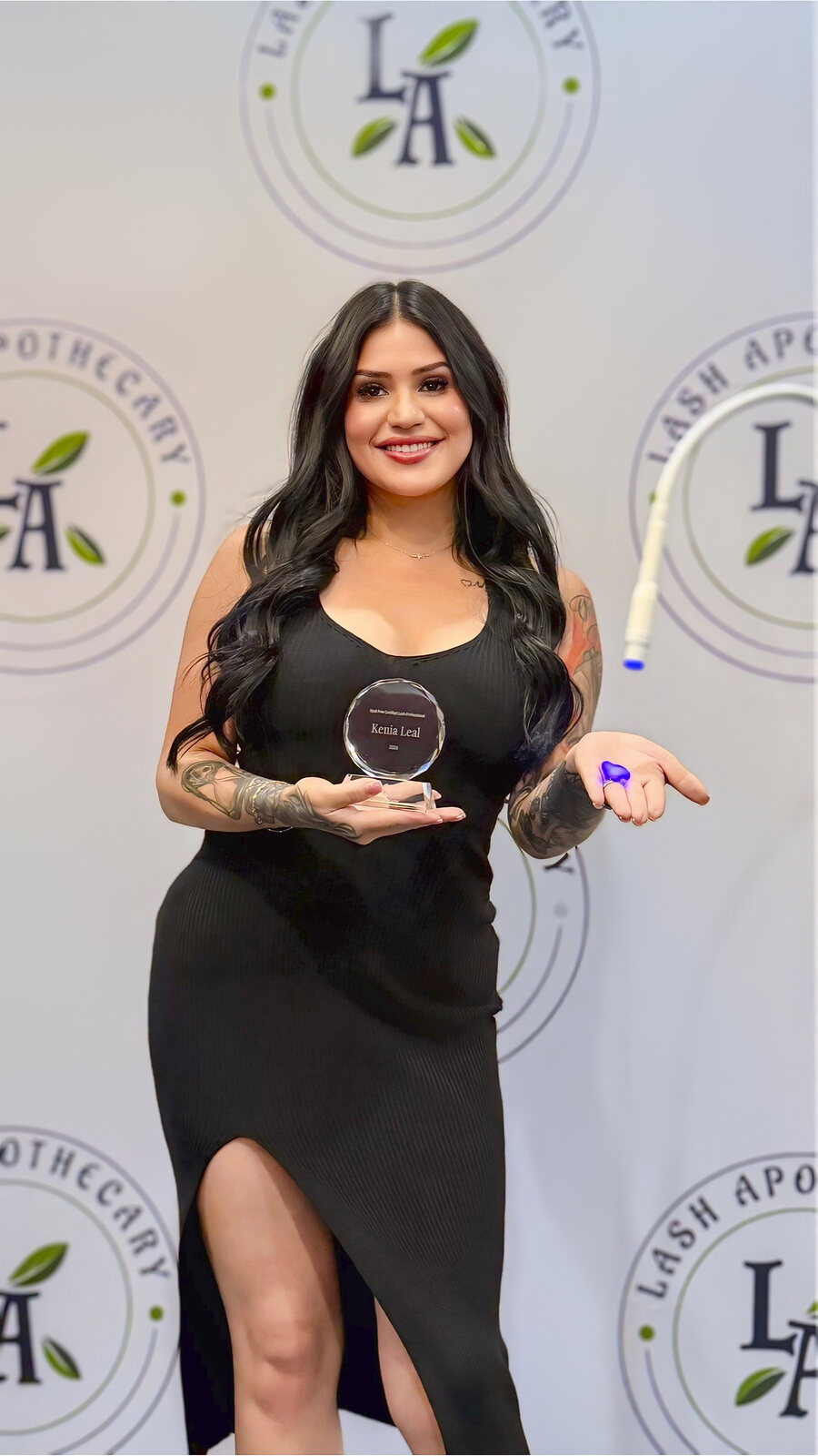 Kenia holding her certification award at Lash Apothecary