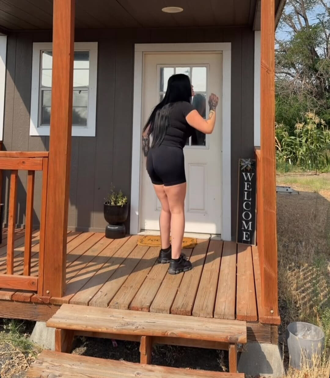 Kenia at her studio door, with its welcome sign